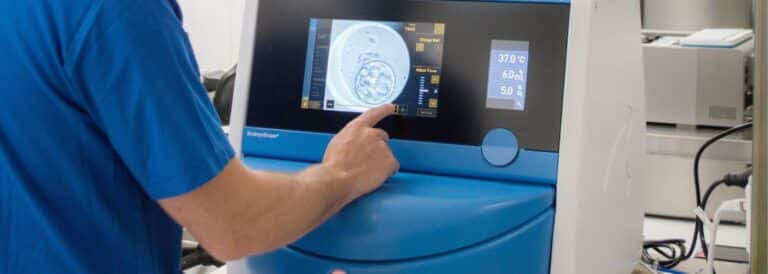 Profesional de laboratorio operando un incubador EmbryoScope+, dispositivo que permite observar y registrar el desarrollo embrionario en tiempo real dentro de un entorno controlado de temperatura y gases.